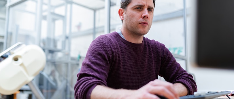 man in purple sweater sitting at the table