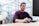 man in purple sweater sitting at the table