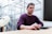 man in purple sweater sitting at the table
