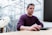 man in purple sweater sitting at the table