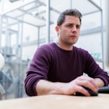 man in purple sweater sitting at the table