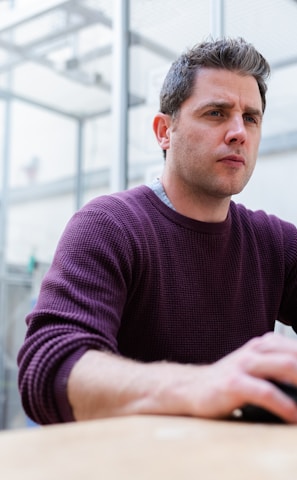 man in purple sweater sitting at the table