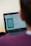 A person is looking at a laptop screen that displays a software interface. The screen shows a graphical layout or design, possibly related to a floor plan or technical drawing. There is also a black coffee mug next to the computer. The person appears to be seated in front of the laptop, focusing on the screen.