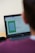 A person is looking at a laptop screen that displays a software interface. The screen shows a graphical layout or design, possibly related to a floor plan or technical drawing. There is also a black coffee mug next to the computer. The person appears to be seated in front of the laptop, focusing on the screen.
