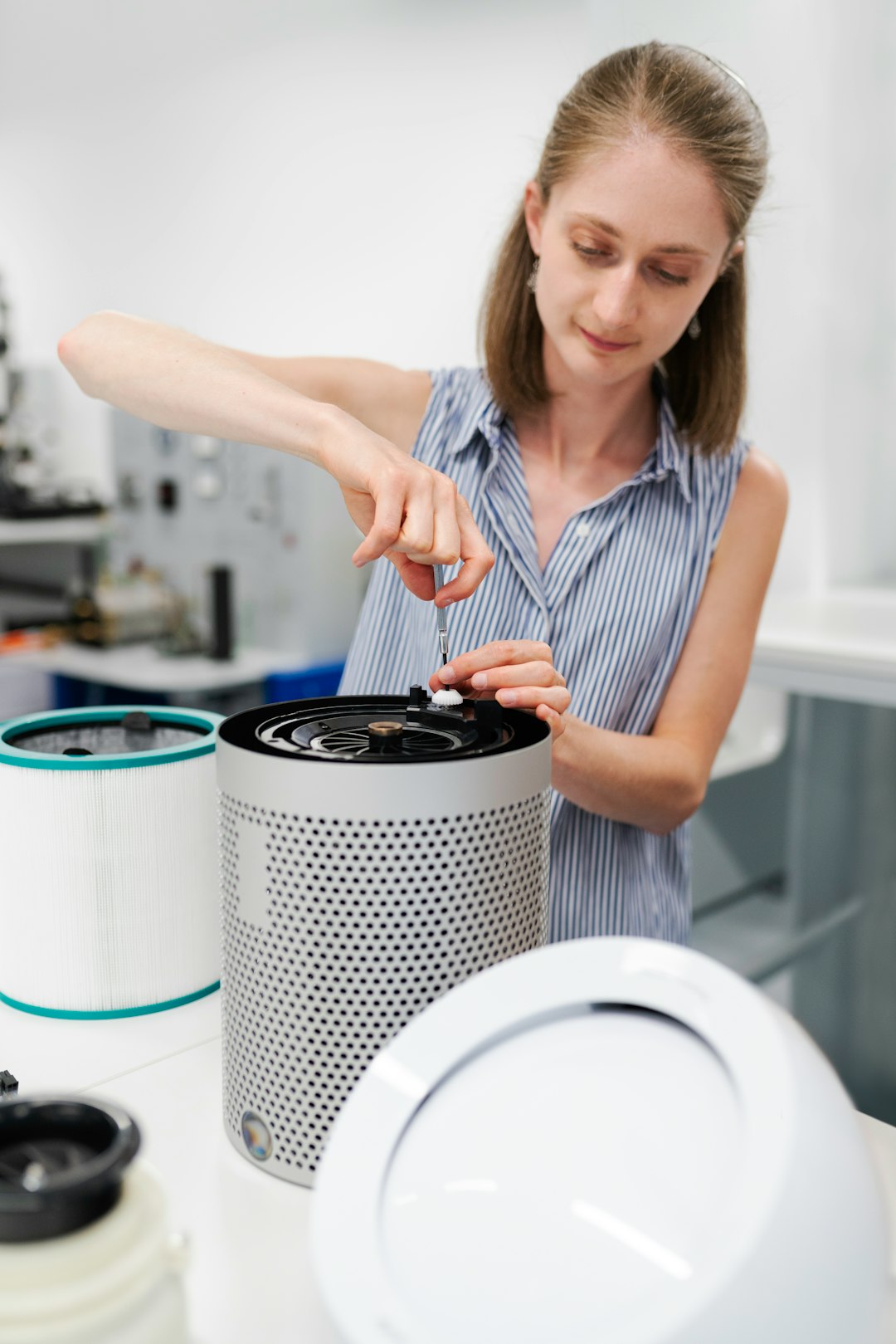 woman in white and black stripe tank top holding black and white round container