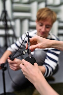 A vocal specialist attentively listening to a vocalist during a session.