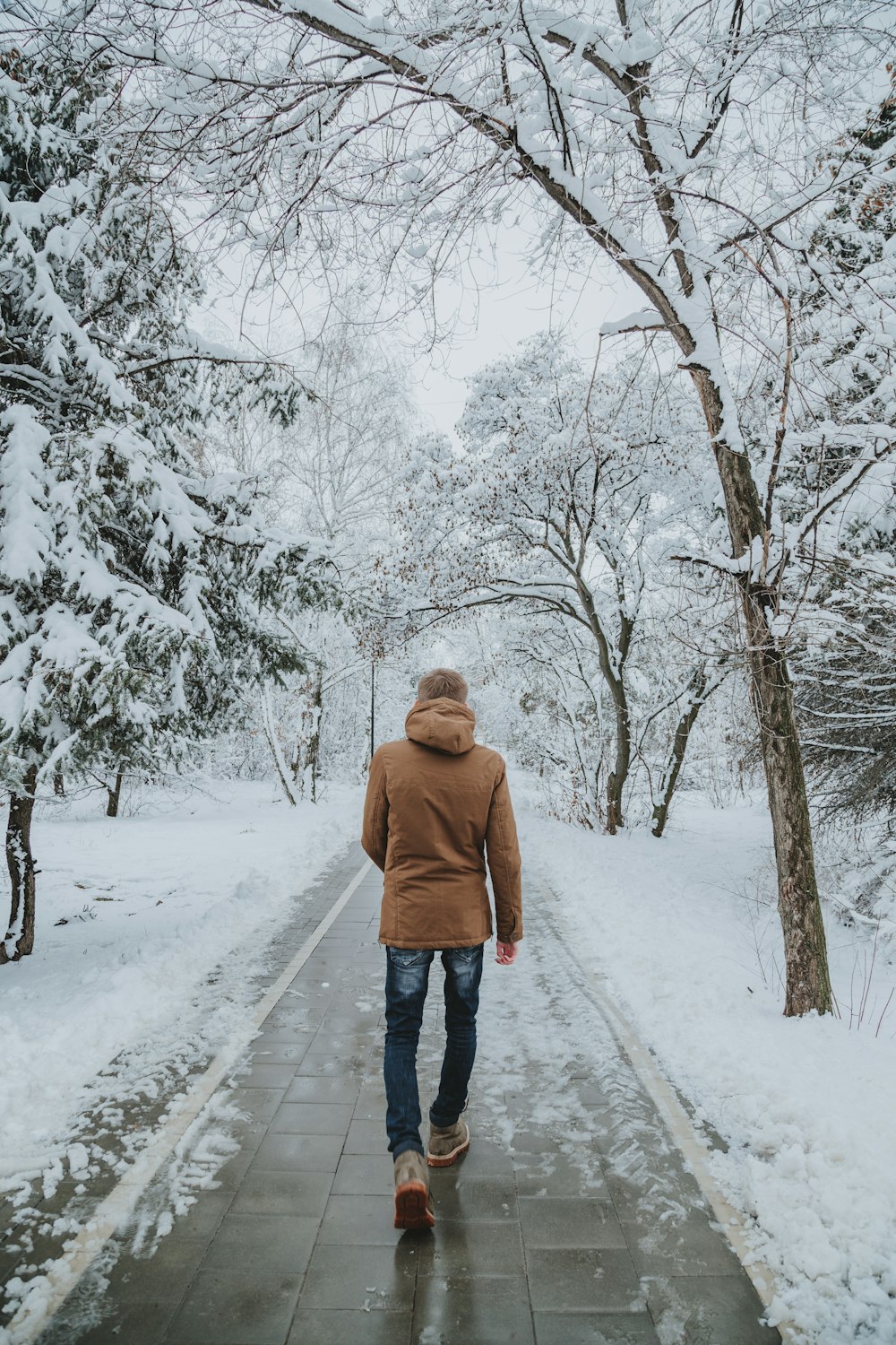 woman in brown hoodie standing on snow covered ground