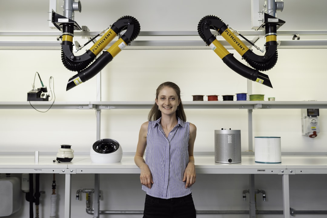 woman in blue sleeveless shirt holding black and yellow power tool, Female noise and vibration engineer in workshop