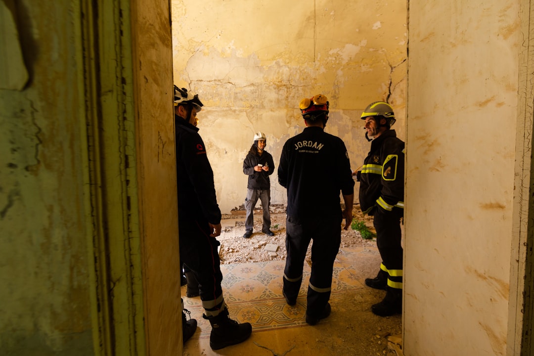 3 men standing beside wall, Structural engineers in disaster relief training