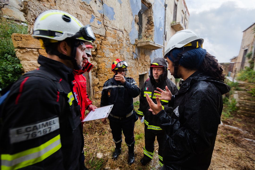 group of people wearing white helmet, Male structural engineer leads disaster relief training in earthquake ruins