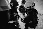 grayscale photo of 2 men in black jacket and helmet