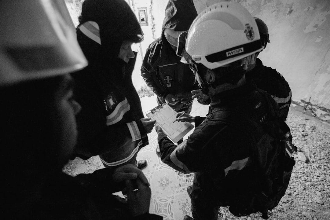 grayscale photo of 2 men in black jacket and helmet