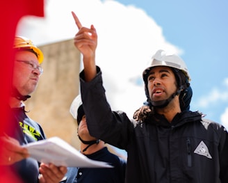 man in black jacket wearing yellow hard hat