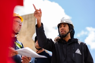 man in black jacket wearing yellow hard hat