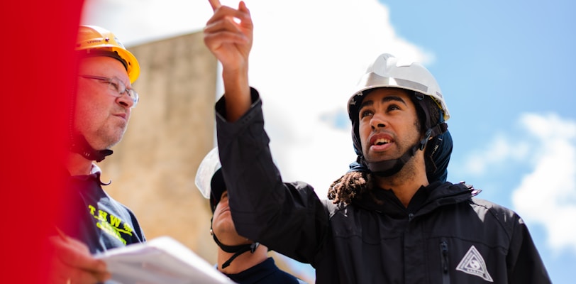 man in black jacket wearing yellow hard hat