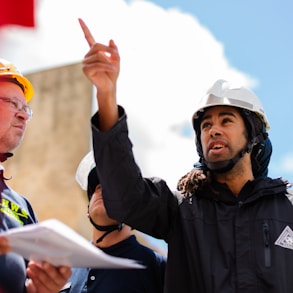 man in black jacket wearing yellow hard hat