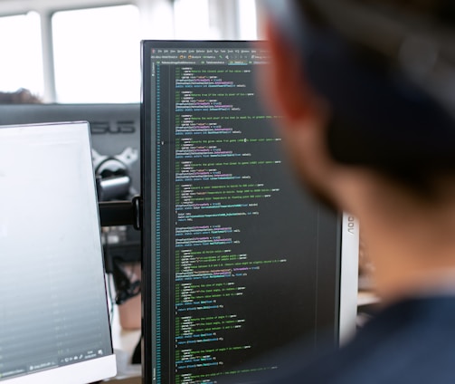 man in black shirt sitting in front of computer monitor