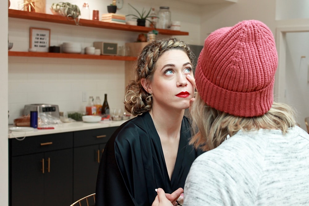 woman in black v neck shirt and red knit cap