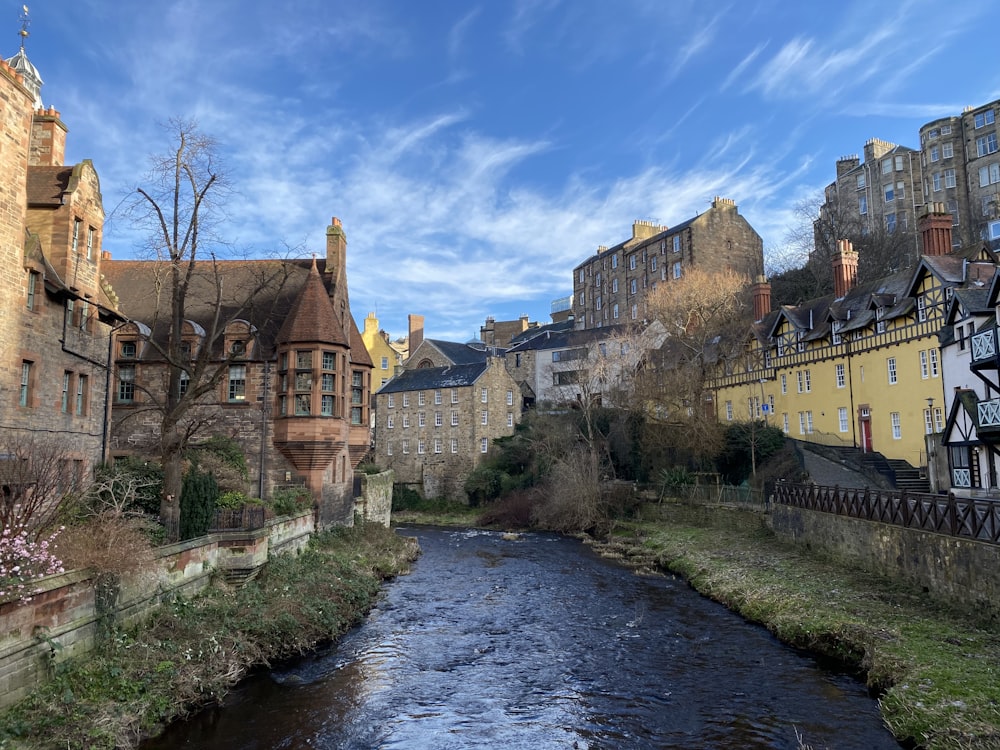 Braunes Betongebäude am Fluss unter blauem Himmel tagsüber