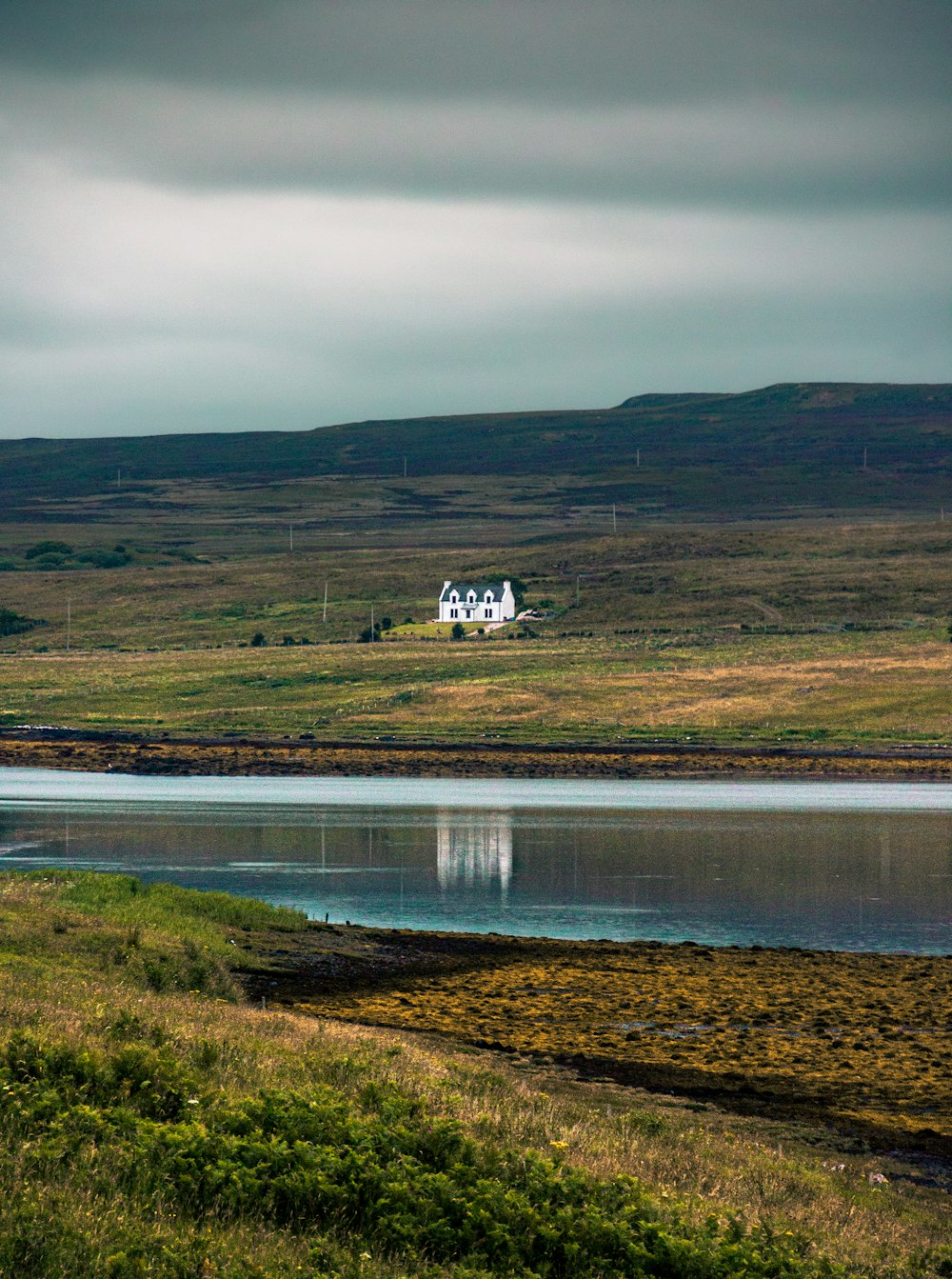 white and brown house near body of water during daytime