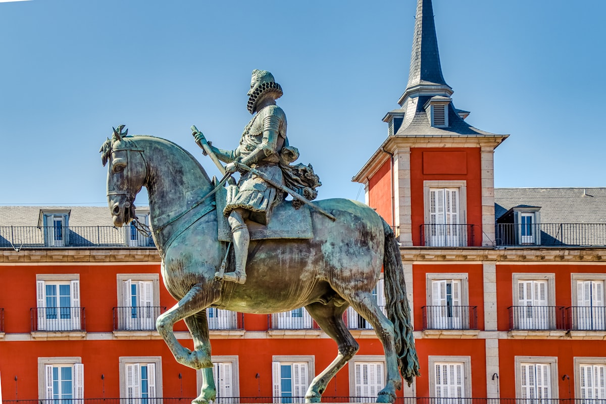 man riding horse statue near brown concrete building during daytime