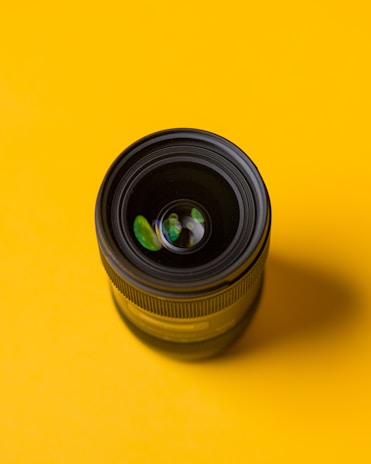 Close-up of lenses reflecting the pink and yellow brand colors in a stylish setting