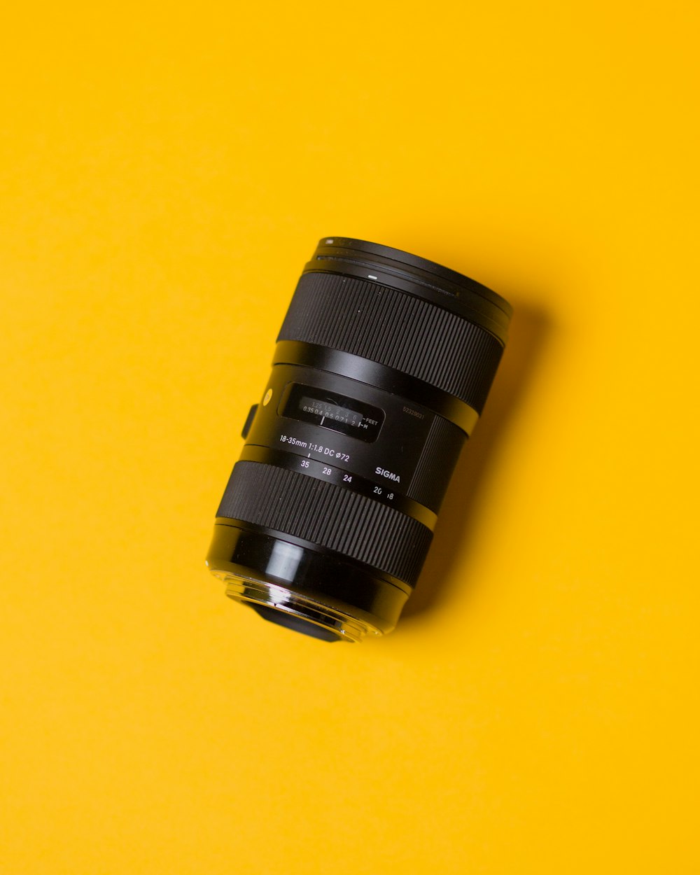 black camera lens on yellow surface