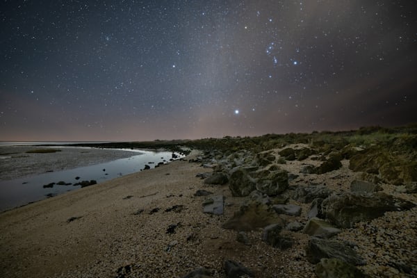 brown rocky shore under blue sky during night time