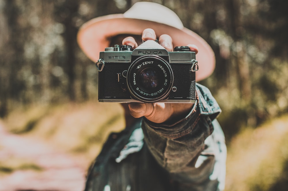 person holding black and silver camera