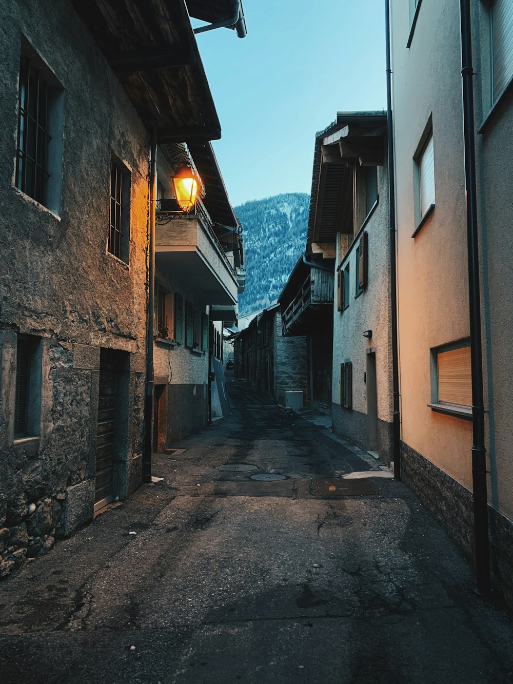 empty street between concrete houses during daytime