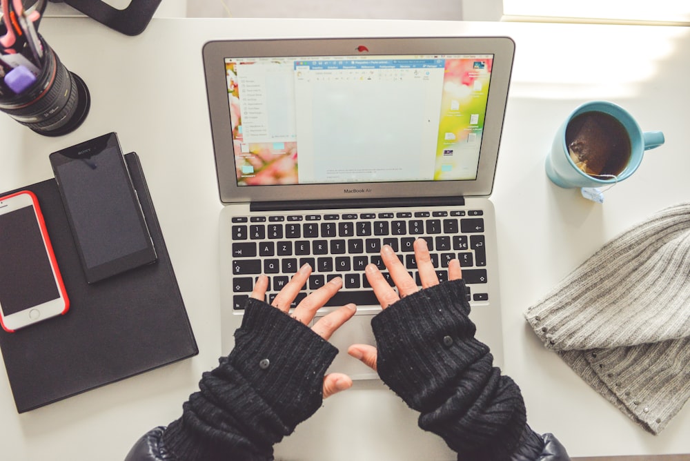 person in black long sleeve shirt using macbook pro