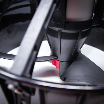 Close-up of a custom 3D printed fan cover featuring a sharp, angular design in pink and black.