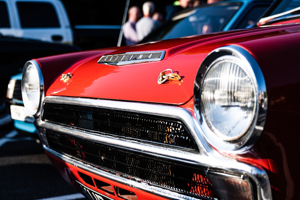 red and silver car in front of people