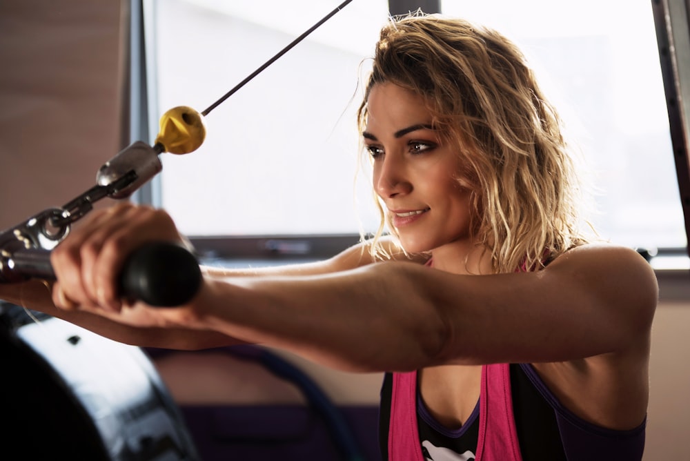 woman in purple tank top holding black microphone