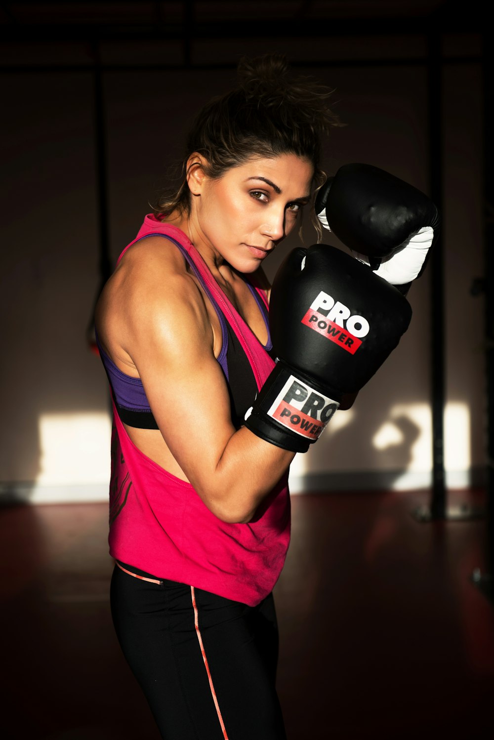 woman in pink tank top and black boxing gloves