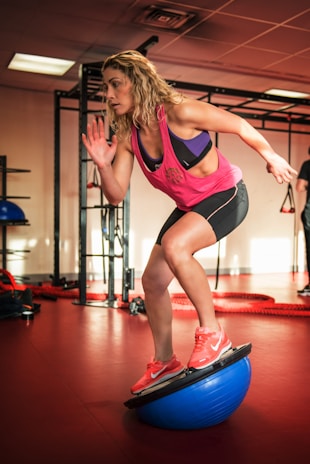 woman in purple tank top and black shorts doing yoga