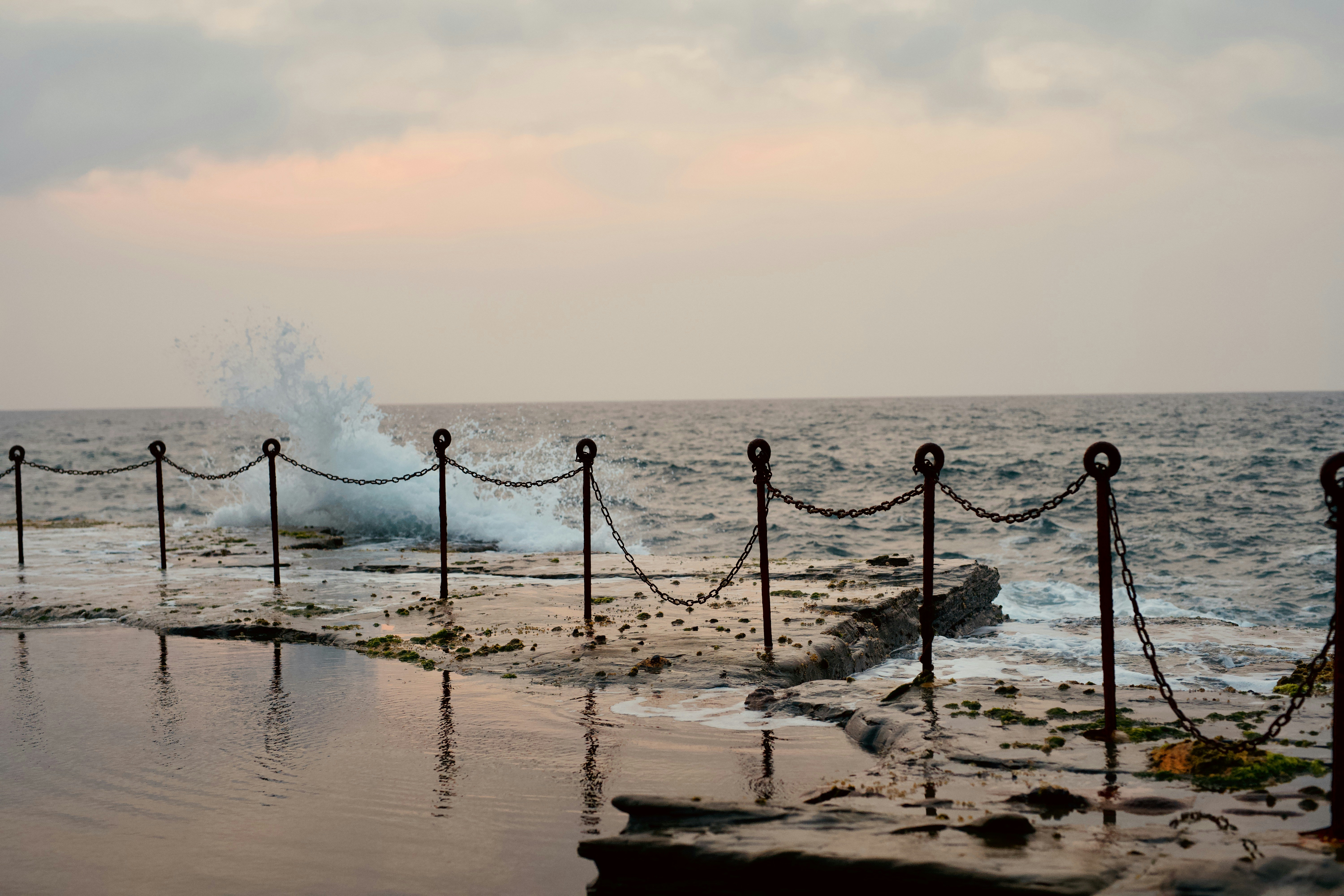 black metal fence on seashore during daytime