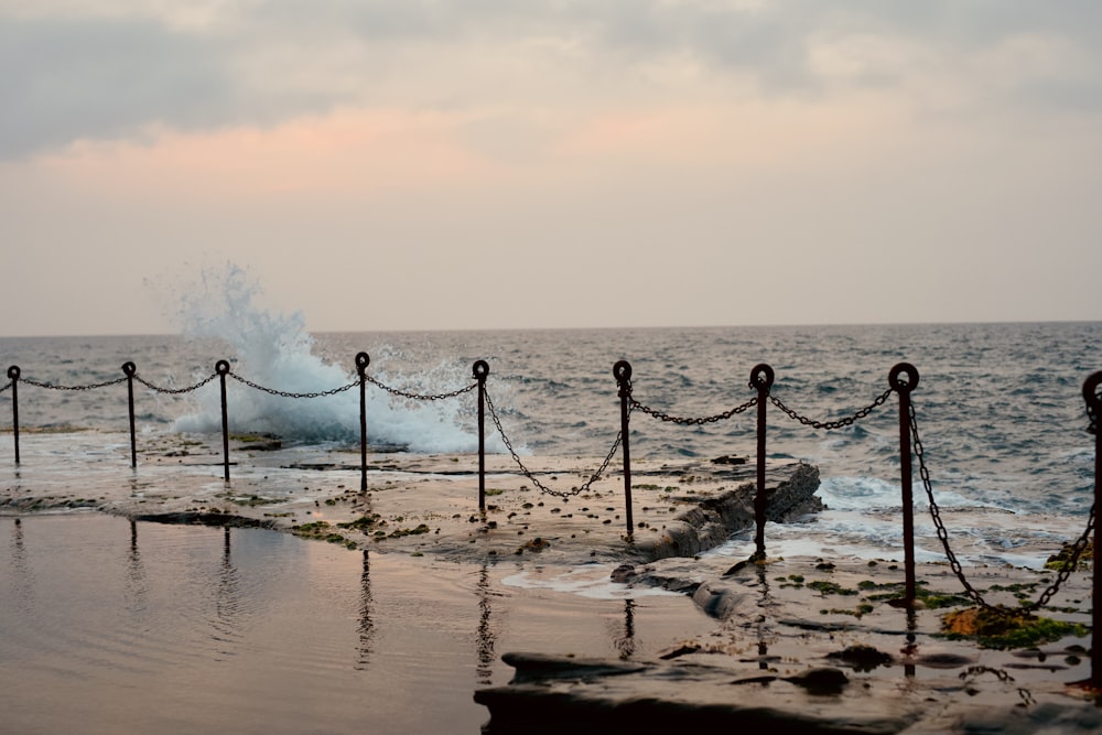 black metal fence on seashore during daytime