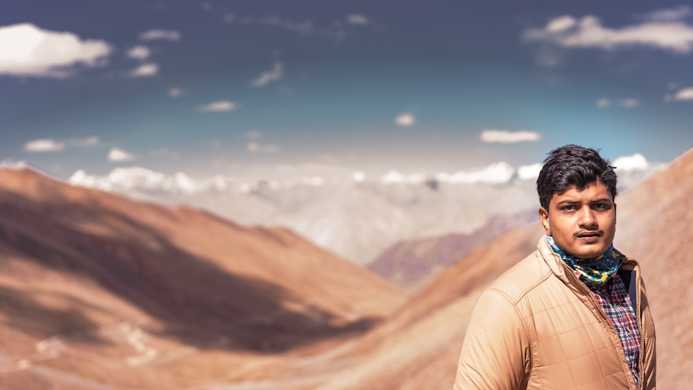 person in white shirt standing on brown mountain during daytime