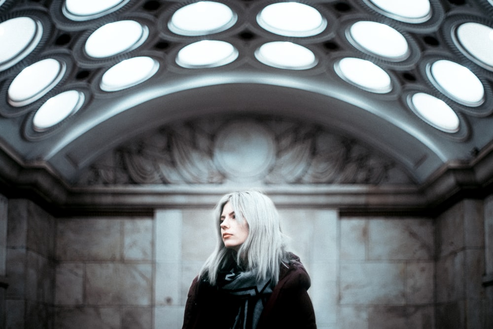 woman in black jacket standing in front of round window