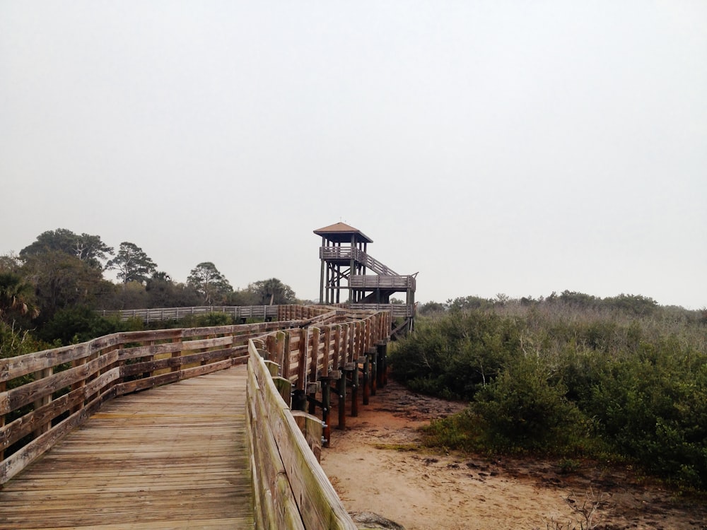 brown wooden bridge near brown wooden house during daytime