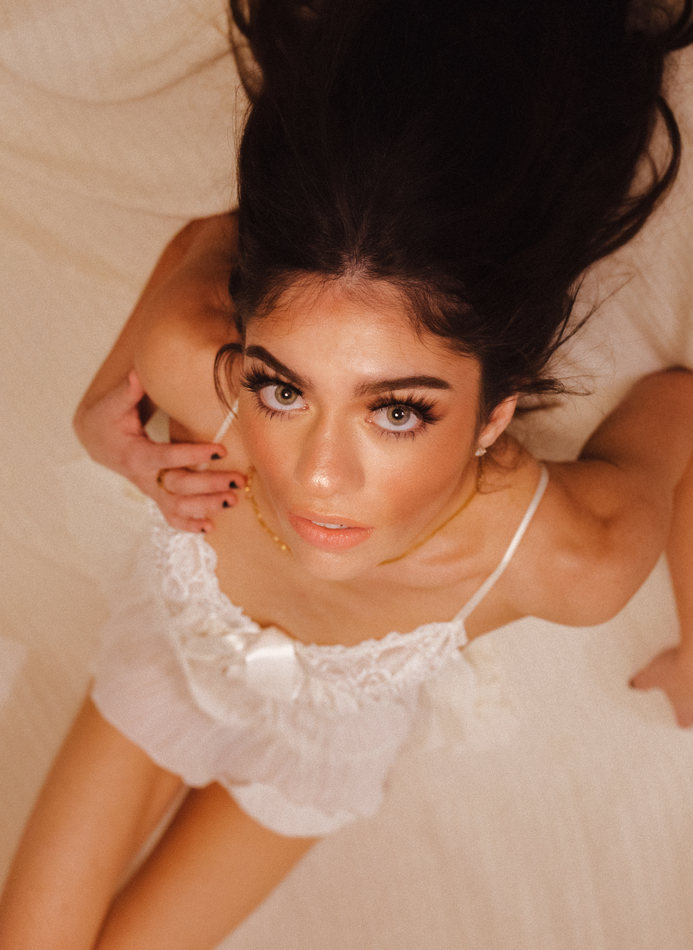 woman in white floral dress lying on bed