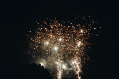 Close-up of fireworks exploding in vibrant colors against dark sky.