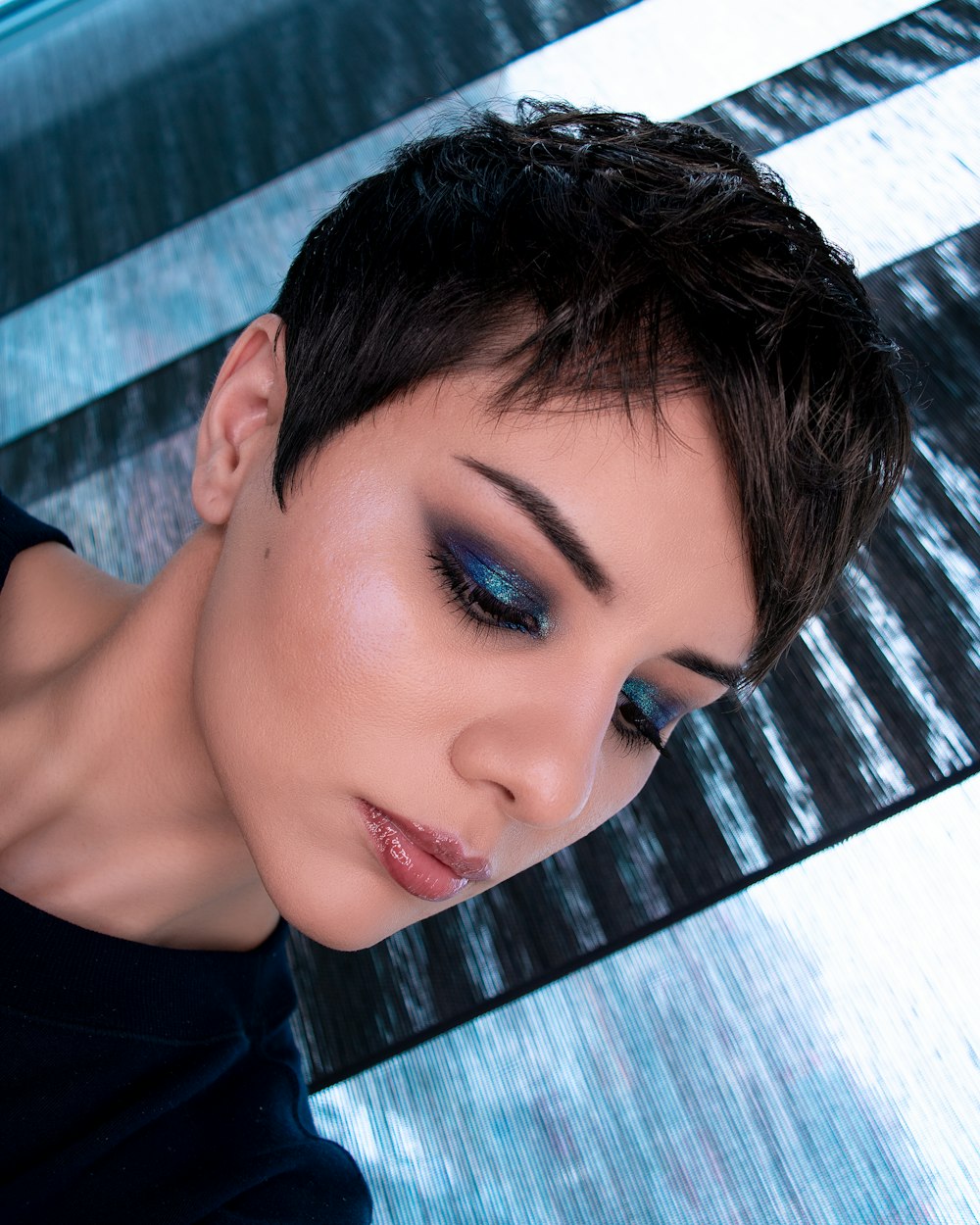 woman in black shirt lying on blue and white stripe textile