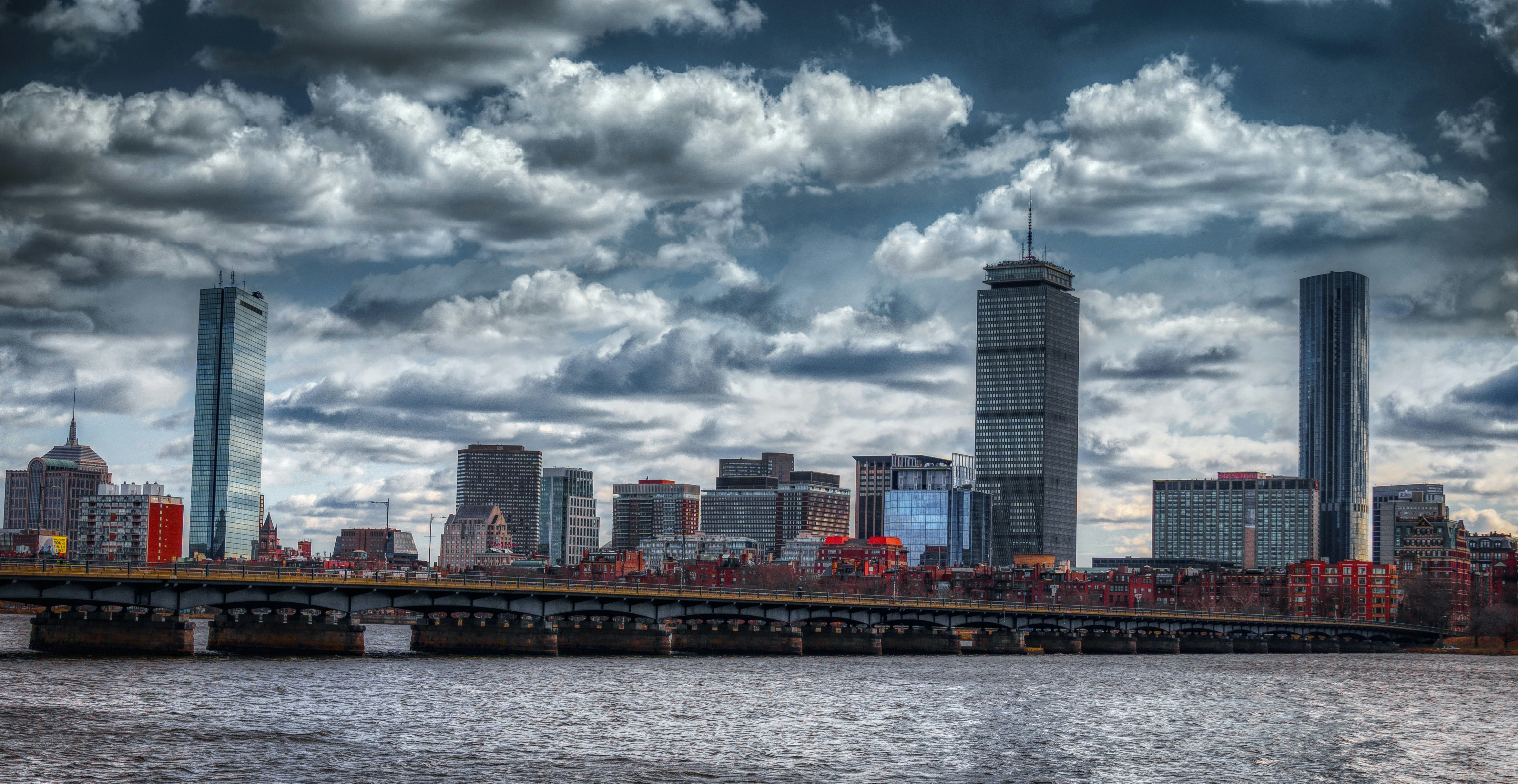 city skyline across body of water under cloudy sky during daytime