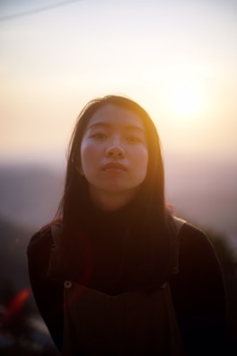 A serene portrait of a model illuminated by golden hour sunlight in an outdoor setting.