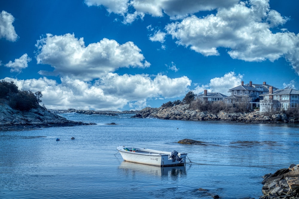 white boat on sea under blue sky and white clouds during daytime