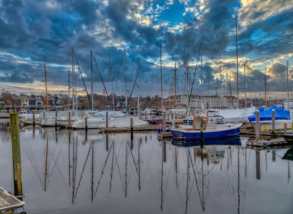 white and blue boats on body of water under blue and white cloudy sky during daytime