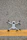 A drone with black propellers is positioned on a textured asphalt surface with a prominent yellow line running horizontally beneath it.