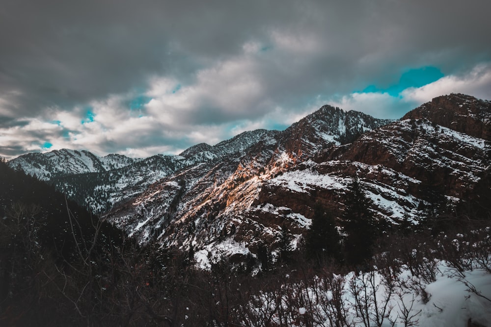 snow covered mountain under cloudy sky during daytime